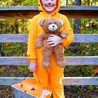boy in Garfield costume with stuffed Pooky the Teddy Bear and lasagna pan with trick or treat bucket