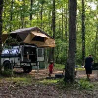 family in Ozark National Forest dispersed camping with rooftop tent on camp trailer with kitchen setup