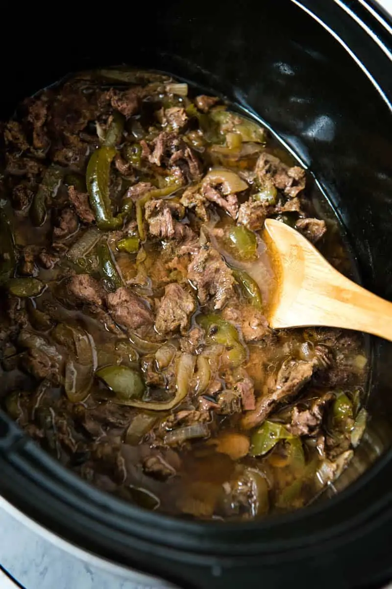 sirloin steak cooked in black Crock Pot slow cooker with onions, green bell peppers, garlic, Worcestershire sauce, and beef broth