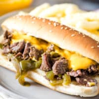 Crock Pot Philly cheesesteak on gray plate with Cheetohs and Cheez Whiz