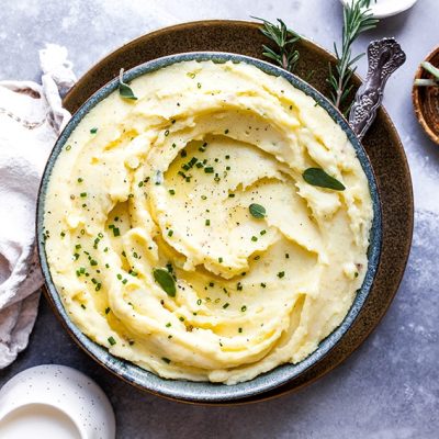 best mashed potatoes, sprinkled with green herbs, in blue bowl