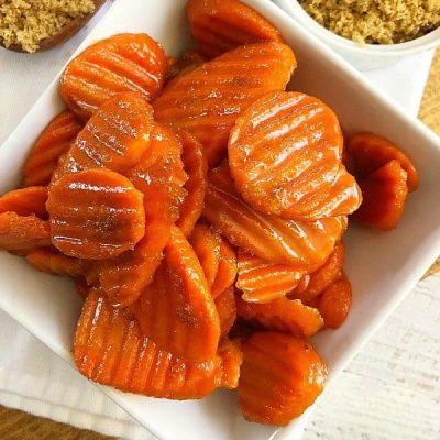 cooked candied carrots in square white bowl