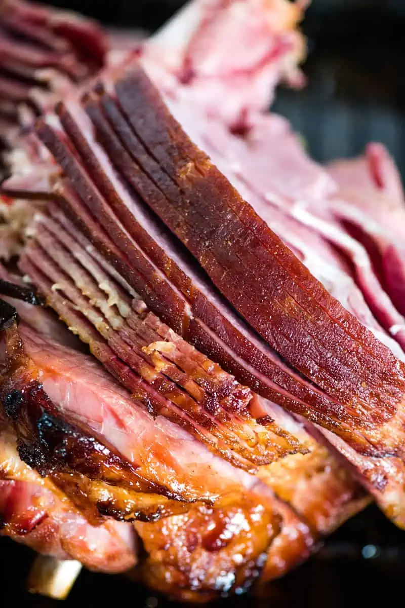 roasted spiral cut bone-in ham in roasting pan for ham
