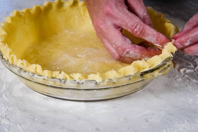 how to flute pie crust or flute edges of pie, in glass pie plate, with fingers
