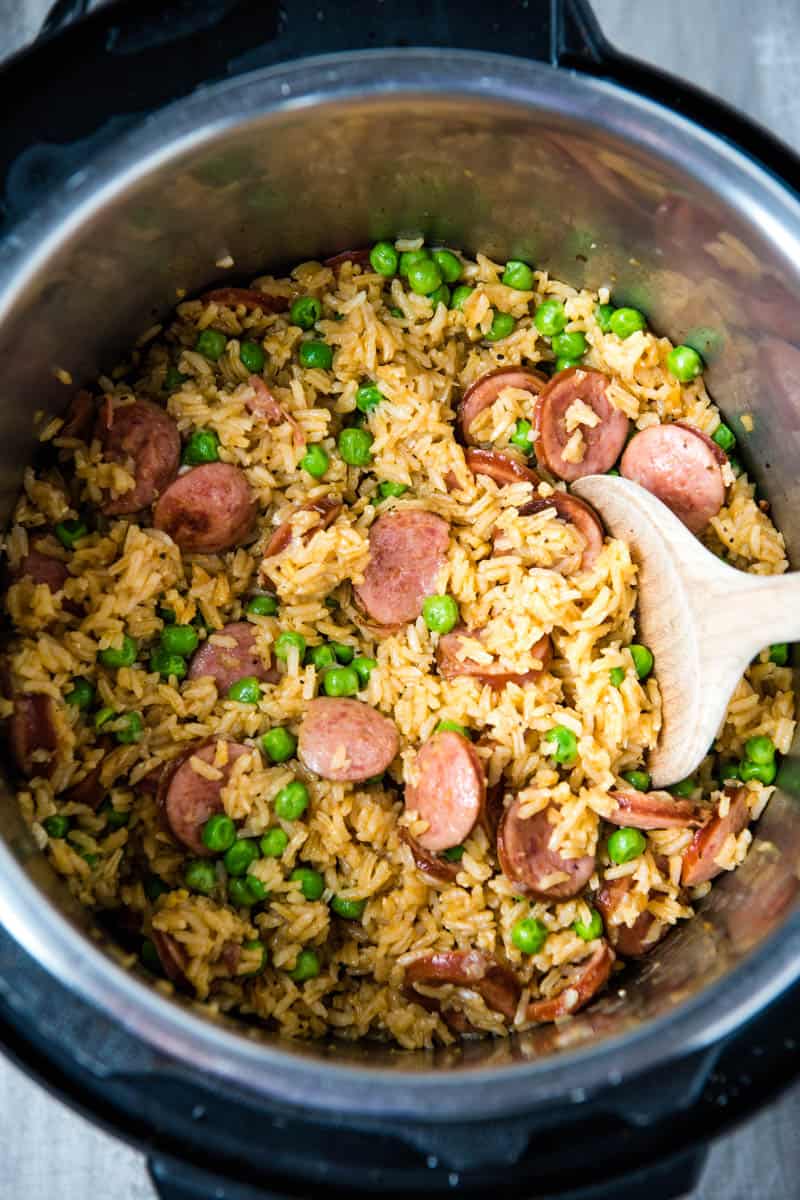 Instant Pot kielbasa and rice with peas and wooden spoon in pressure cooker