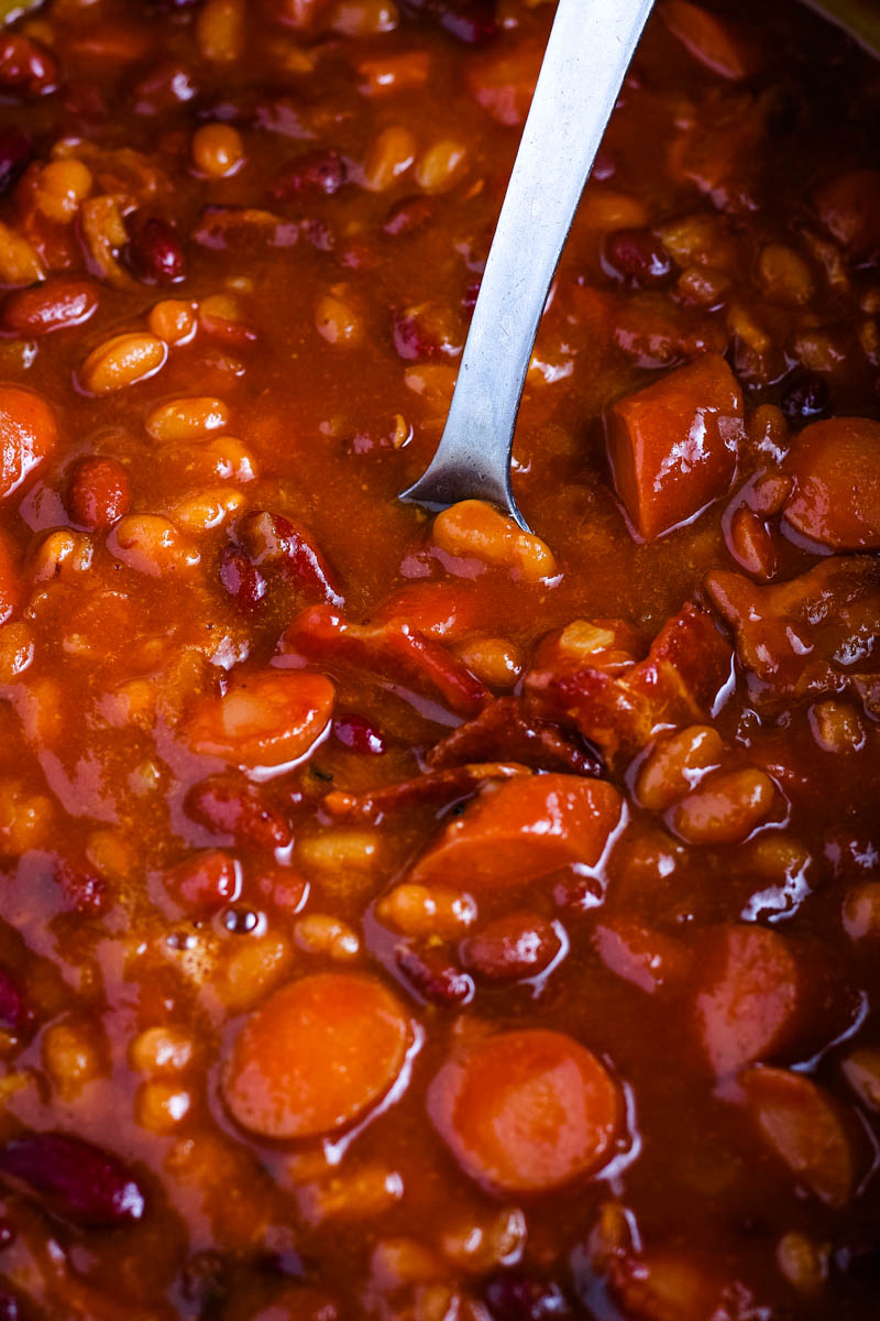 close up picture of slow cooker baked beans with spoon