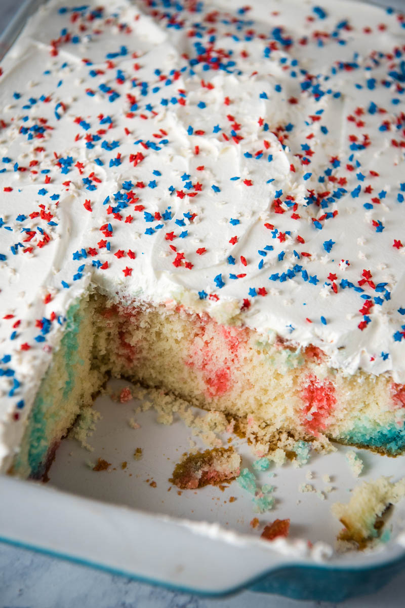 sliced 4th of July poke cake in blue baking dish