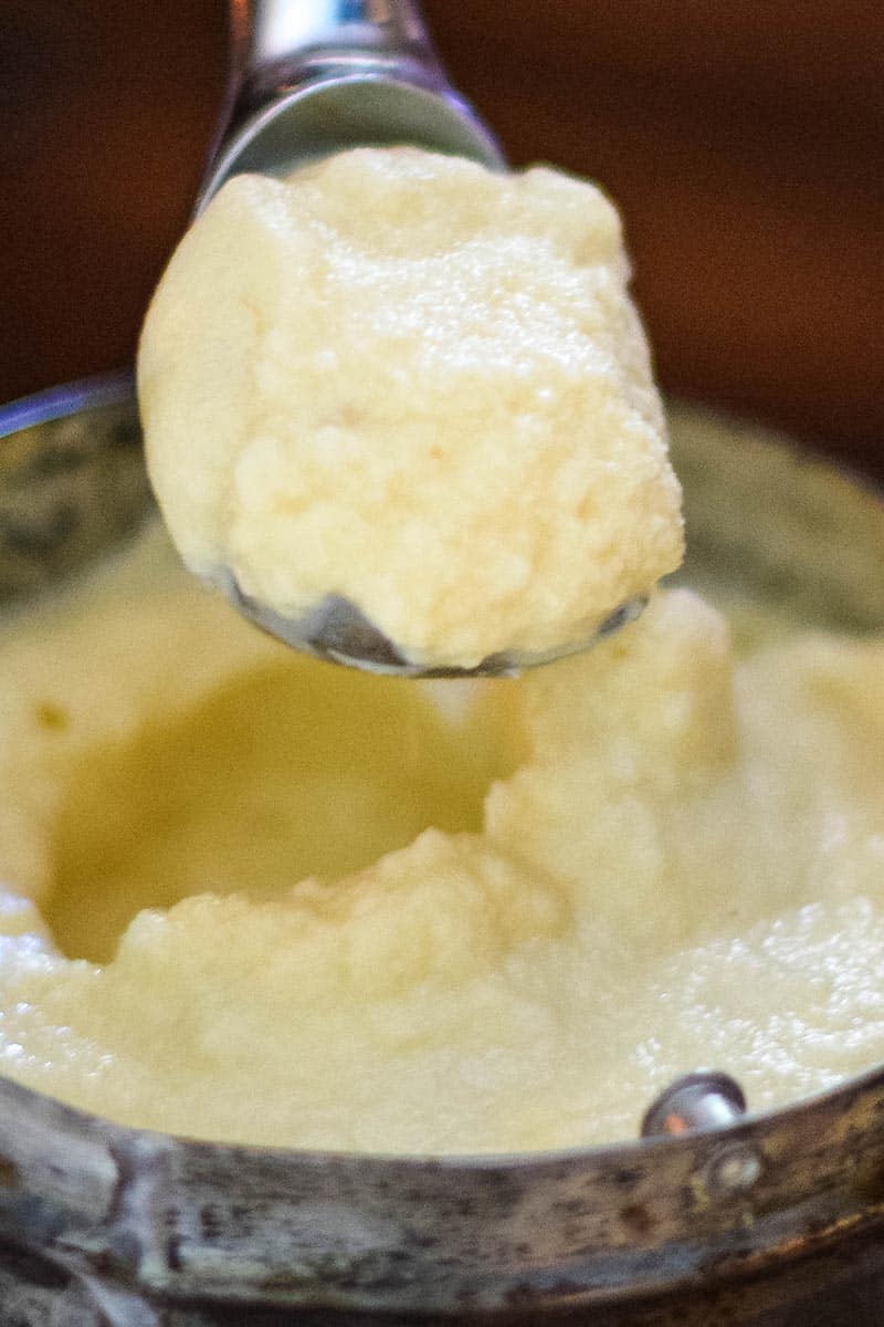 scooping banana ice cream out of ice cream maker