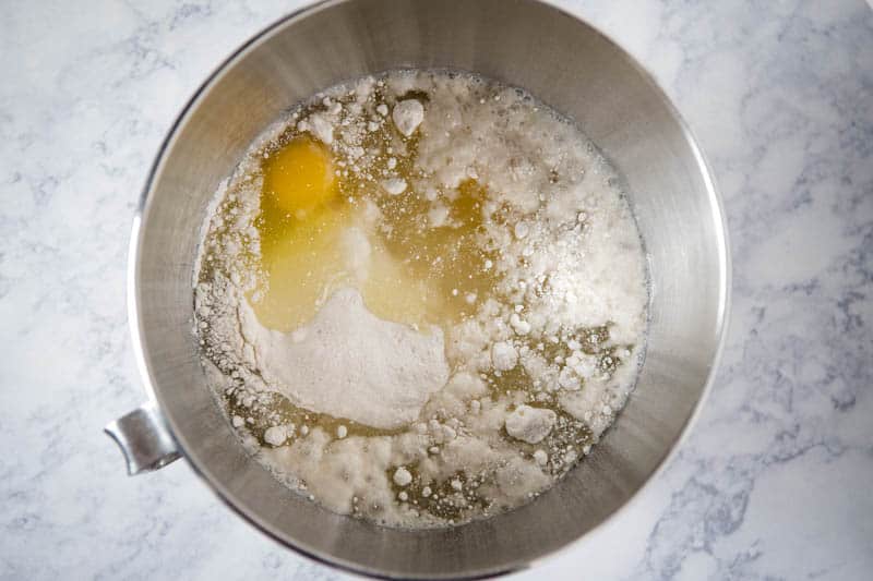 mixing cake mix with water, eggs, and canola oil in metal KitchenAid mixing bowl