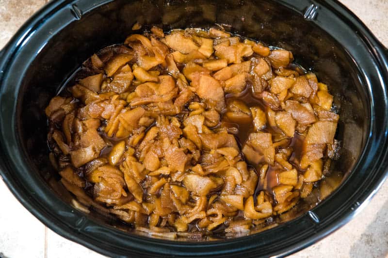 cooked and tender apples in black slow cooker, ready to blend into apple butter