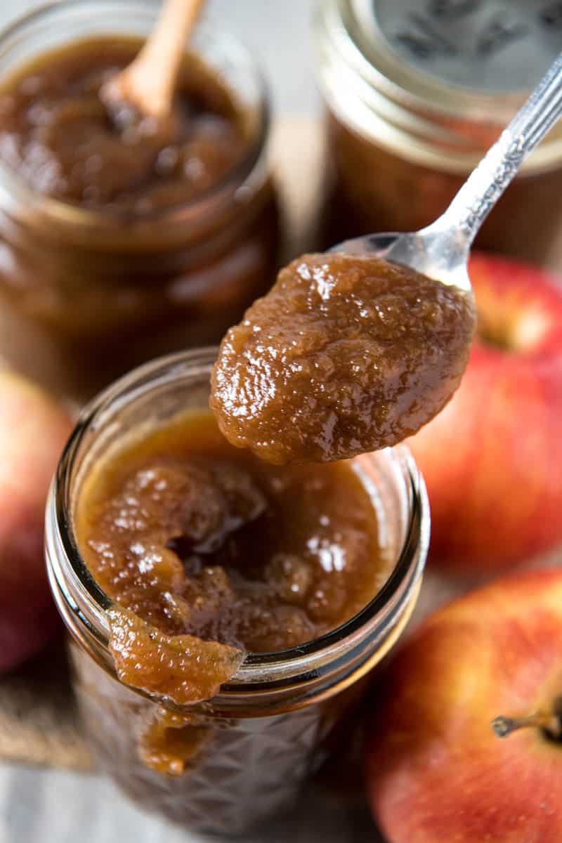spoonful of easy CrockPot apple butter over jar with drips down side
