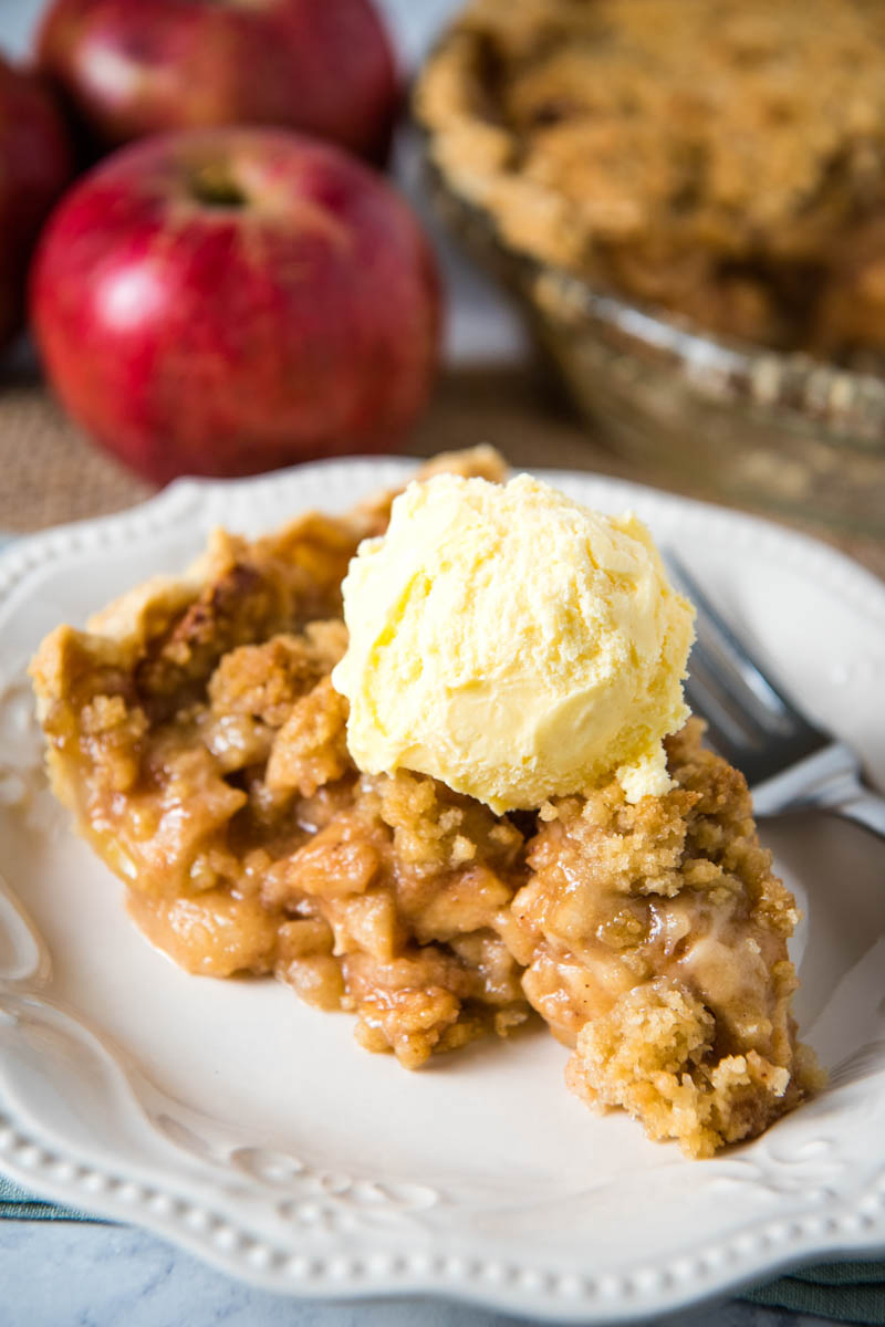 slice of Dutch apple crumb pie with fork on white plate