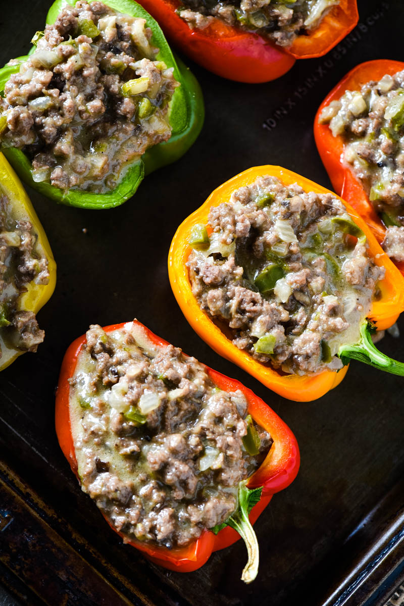 spooned ground beef mixture into Philly cheesesteak stuffed peppers on baking sheet
