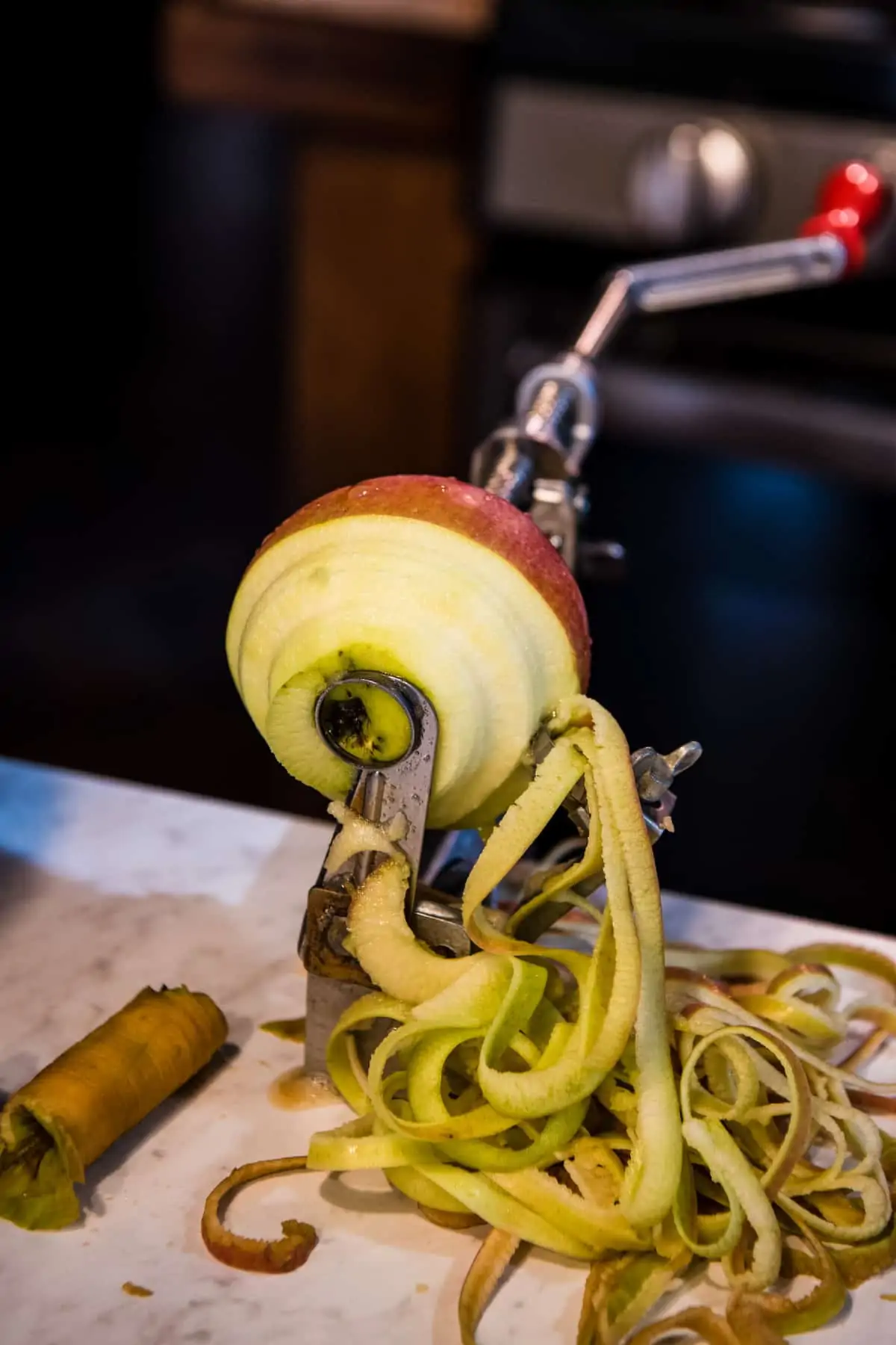 Johnny apple peeler for peeling, coring, and slicing apples on white countertop