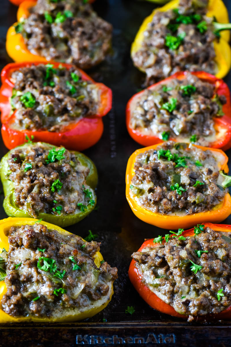 Philly cheesesteak peppers, baked and sprinkled with parsley, on baking sheet