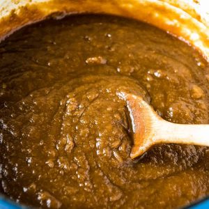 blue Dutch oven with old-fashioned stovetop apple butter recipe and wooden spoon