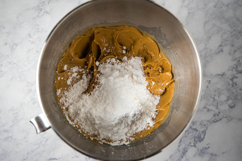 mixing powdered sugar in with peanut butter mixture in large bowl