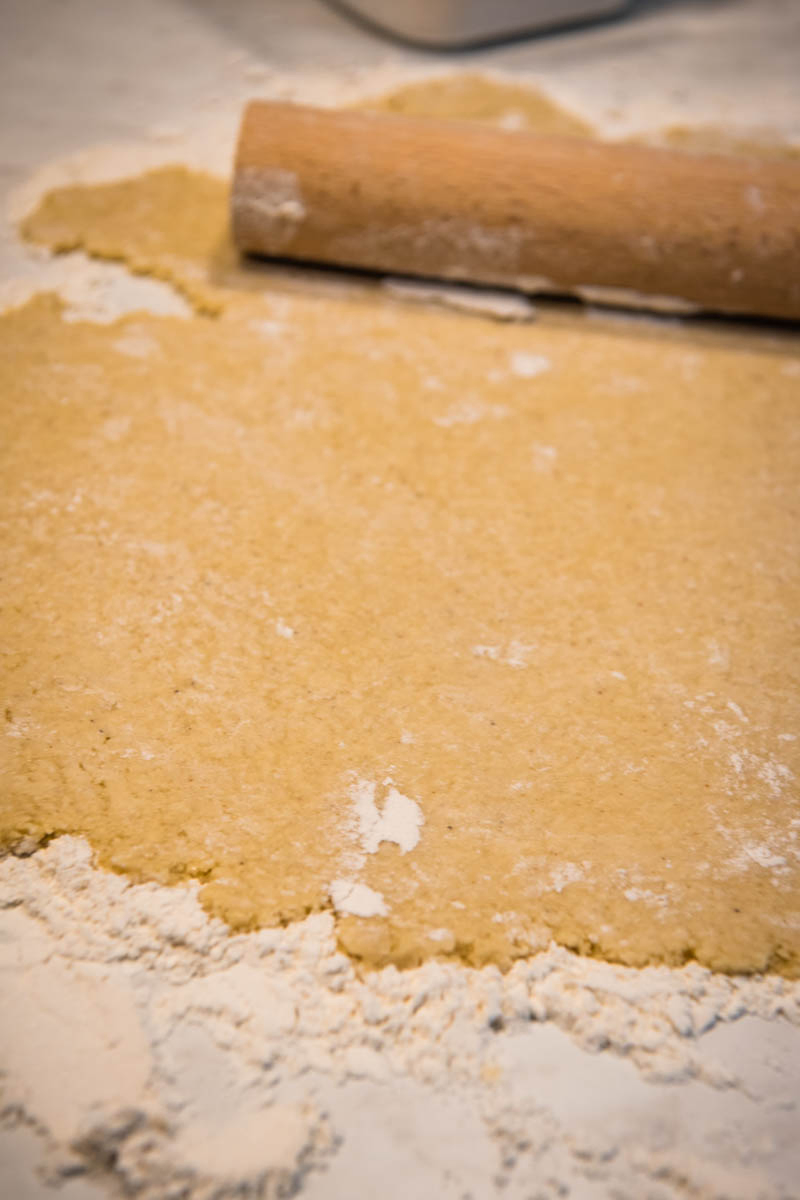 rolled sugar cookies dough on floured surface with rolling pin