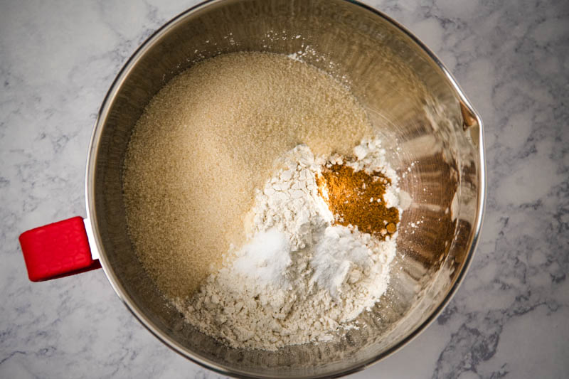 mixing together dry ingredients for cut out sugar cookie recipe in metal mixing bowl
