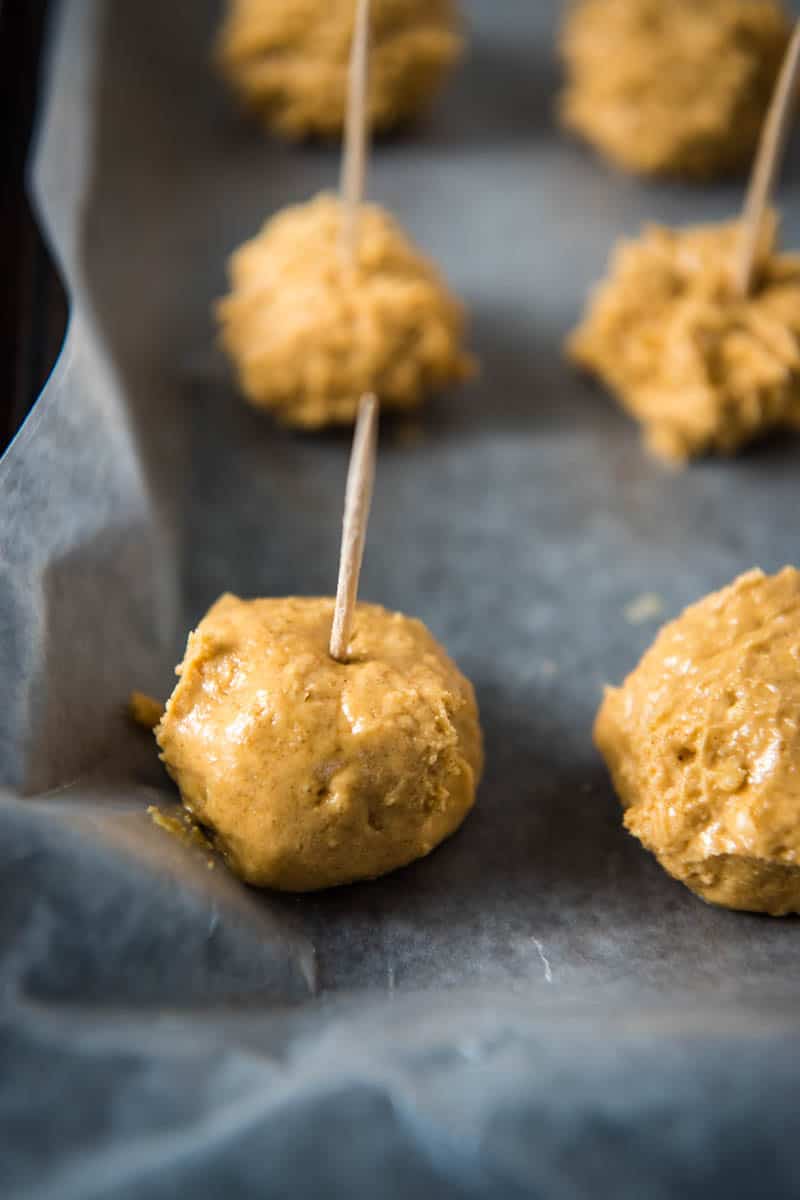 toothpicks added to peanut butter Rice Krispies balls on baking sheet lined with wax paper