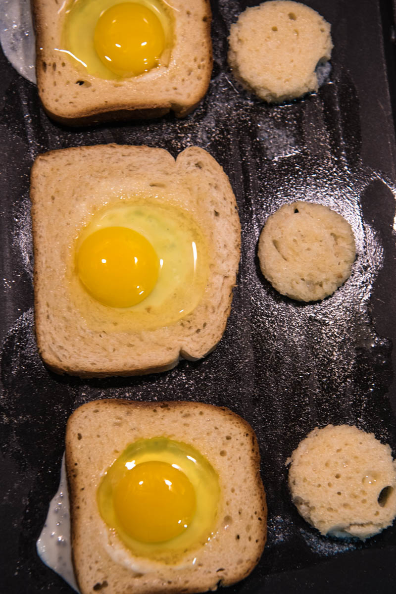 cracked egg in a hole frying on griddle