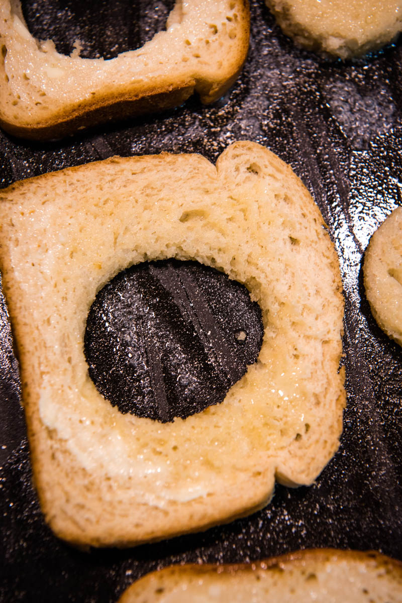 frying buttered bread with hole on griddle
