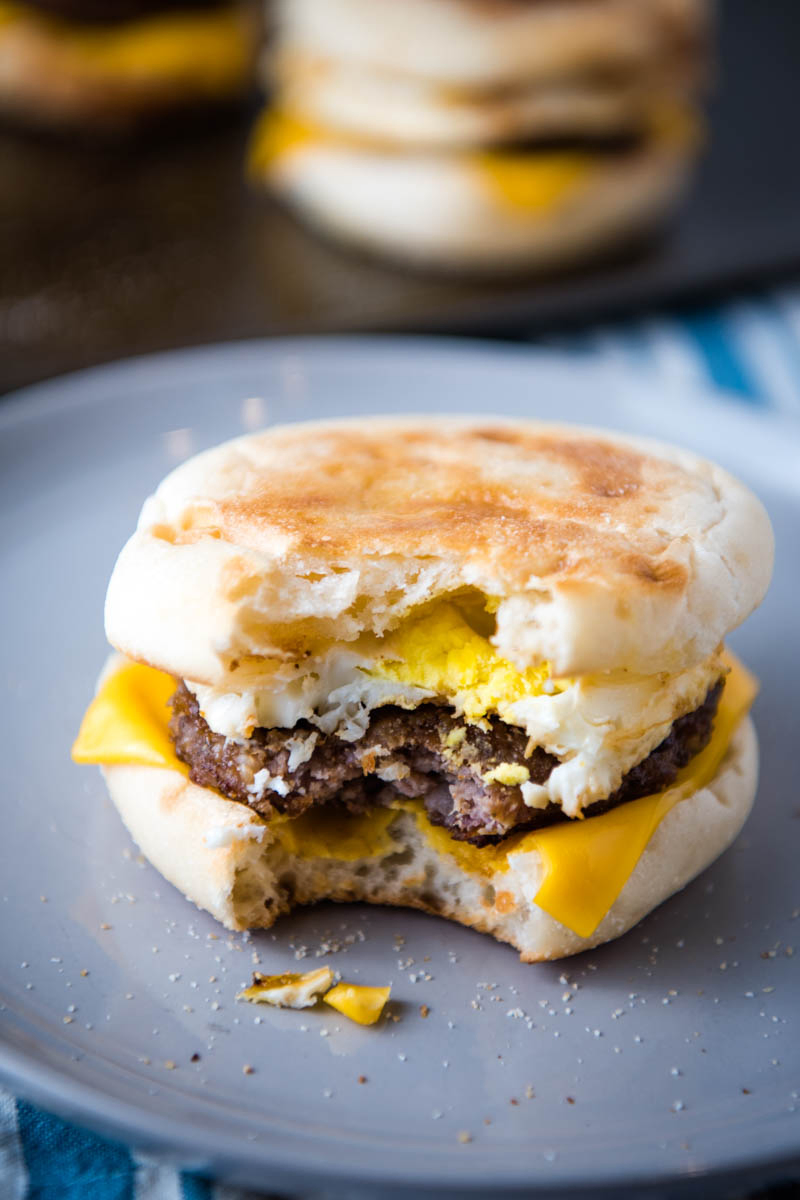 bite out of sausage egg and cheese McMuffin on gray plate