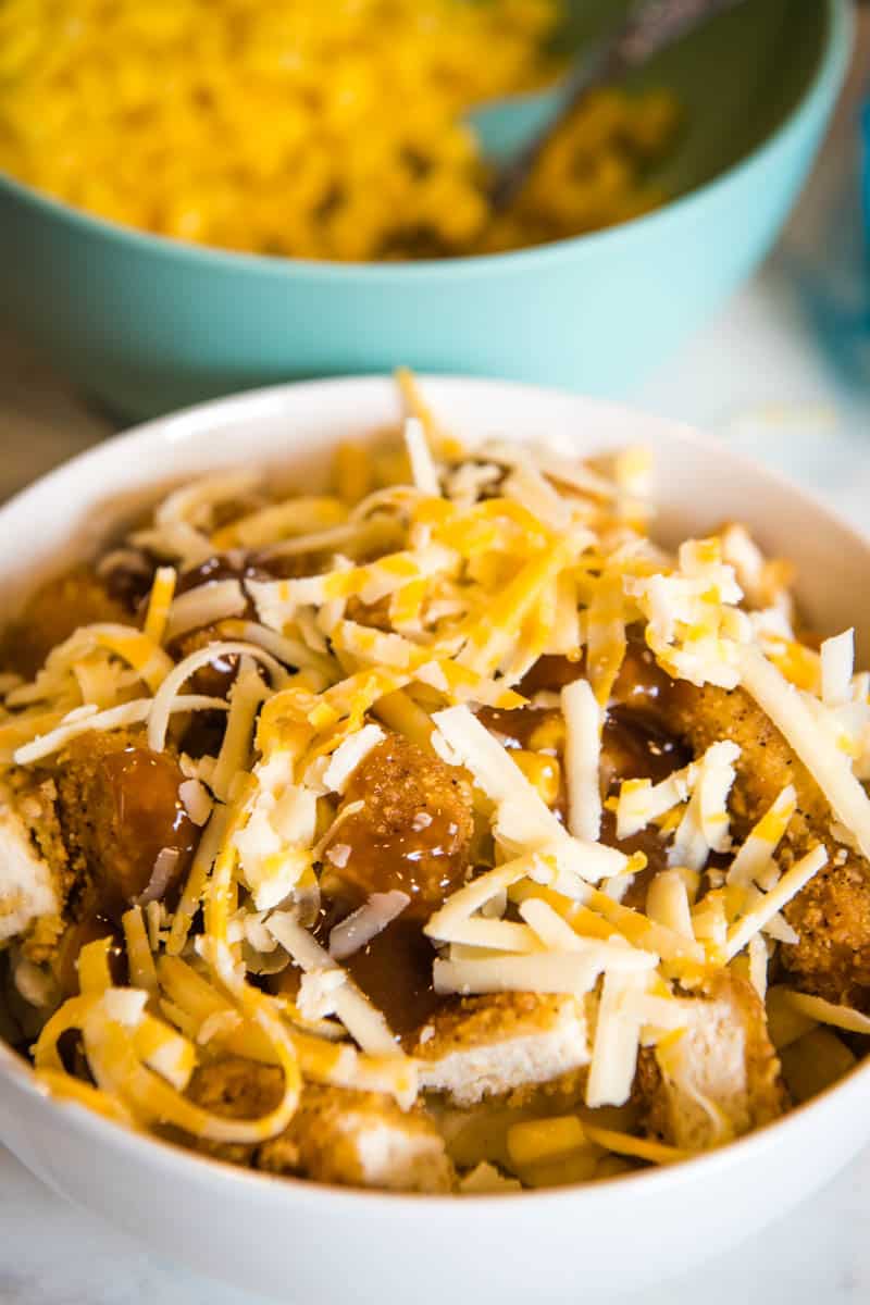 shredded cheese on top of mashed potato bowl in white serving bowl