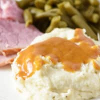 mashed potatoes and ham gravy on rounded white decorative plate