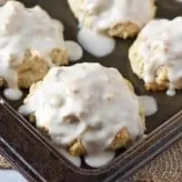 cinnamon biscuits covered with icing on baking sheet