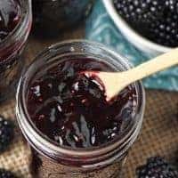 jar of blackberry jam with small wooden spoon