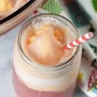 orange sherbet punch in mason jar with candy striped straw