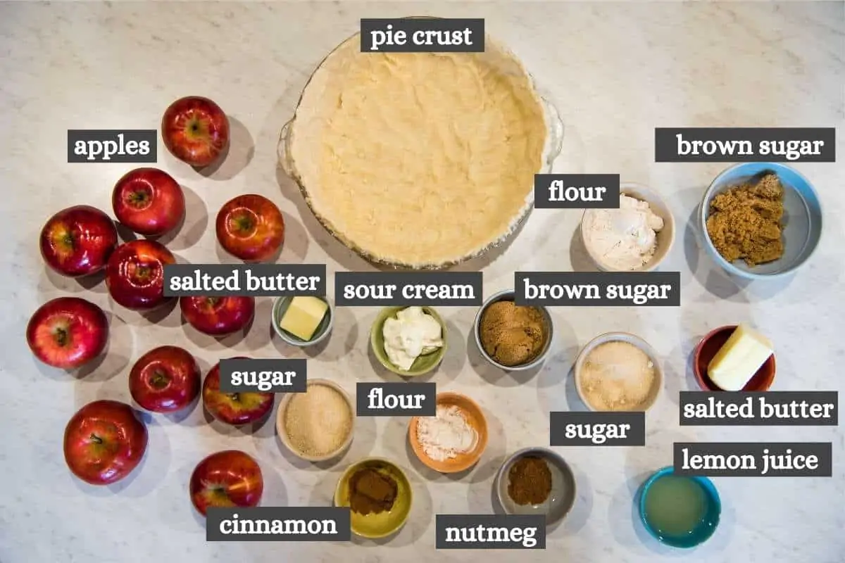 apple crumb pie ingredients on white marble countertop