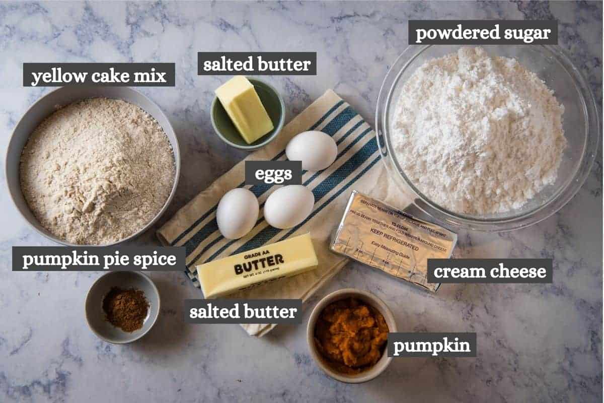 pumpkin spice gooey butter cake ingredients on white marble countertop