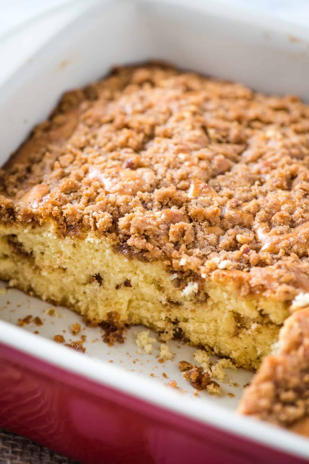 coffee cake with pecans and a streusel topping in red baking dish