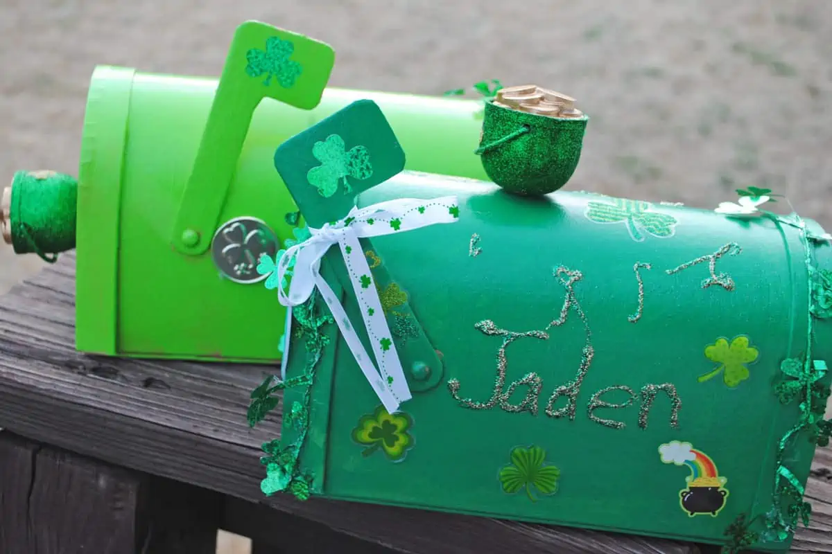 St. Patrick's Day leprechaun boxes decorated, sitting on wood railing