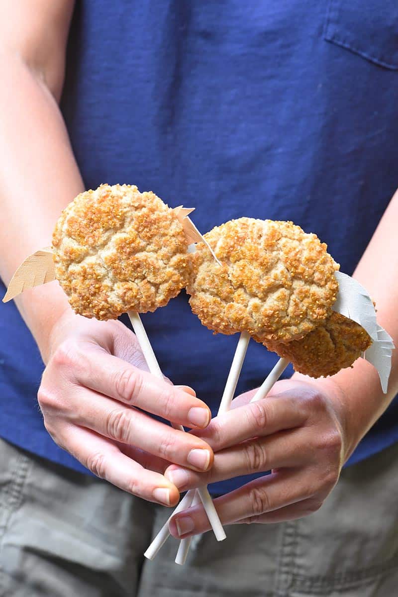 hands holding Golden Snitch snickerdoodle cookie pops