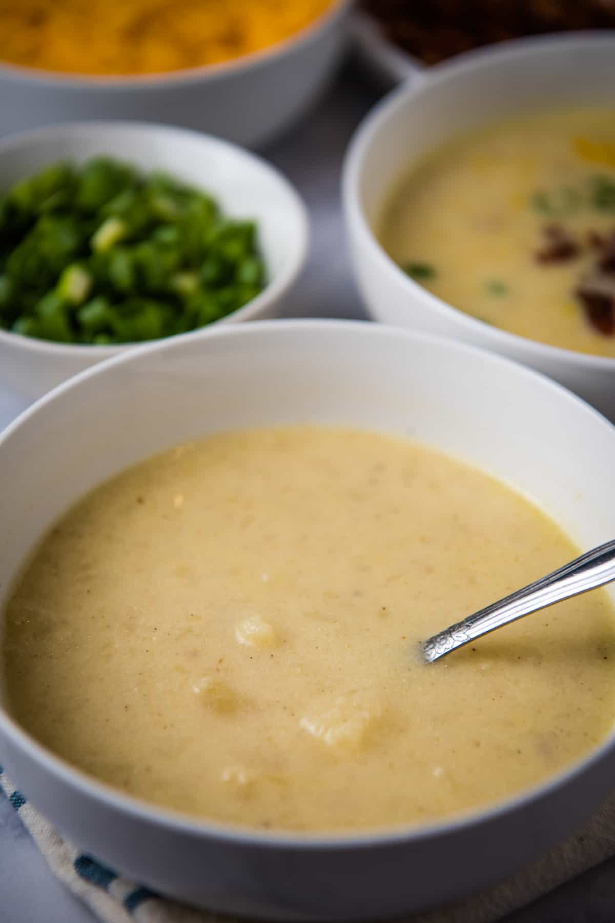 white bowl of creamy pressure cooker potato soup with spoon