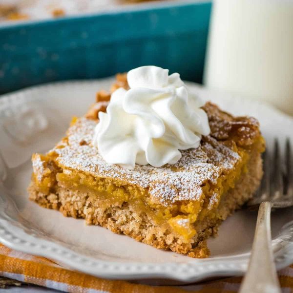 slice of pumpkin gooey butter cake with whipped cream on top