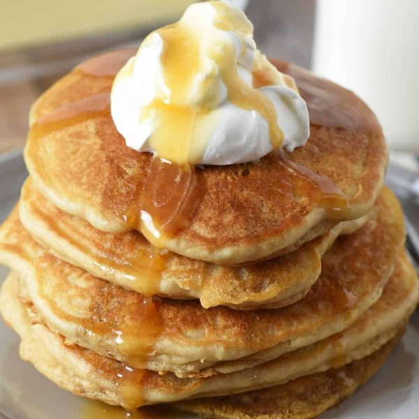 stack of butterbeer pancakes topped with whipped cream and butterscotch sauce