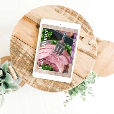 Easter Dinner cookbook on tablet on round wooden cutting board