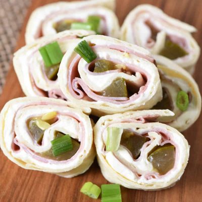 dill pickle ham roll ups on wooden cutting board