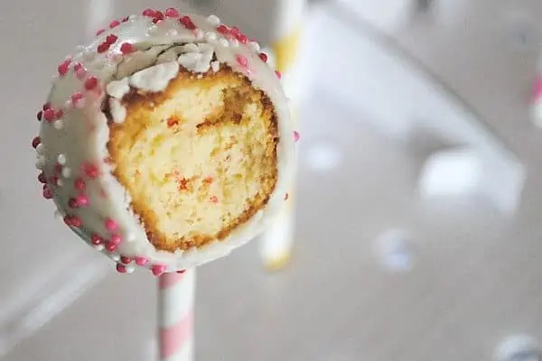 cherry chip Valentines cake pop with nonpareils and bite taken out of it