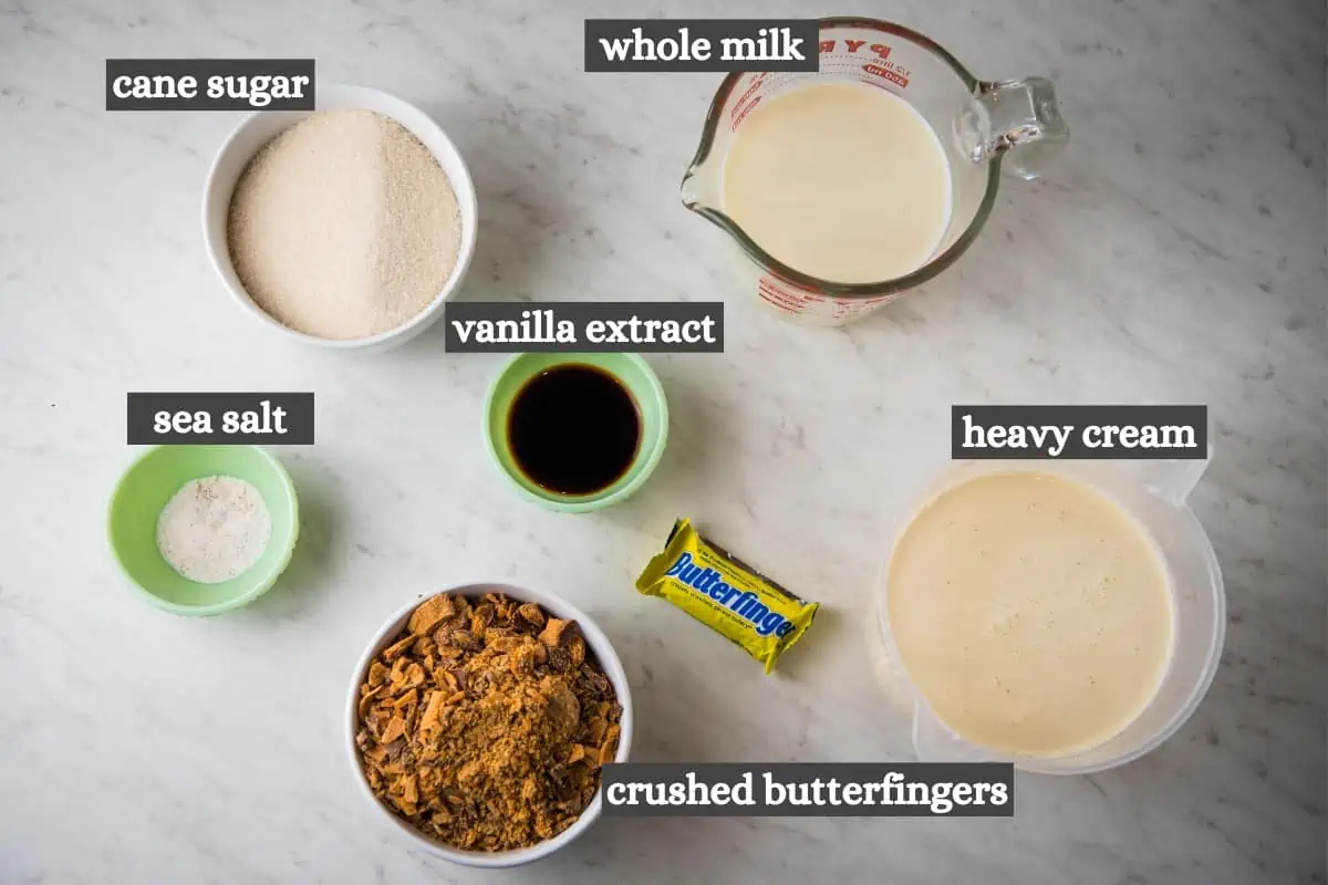 butterfinger ice cream recipe ingredients on white marble countertop