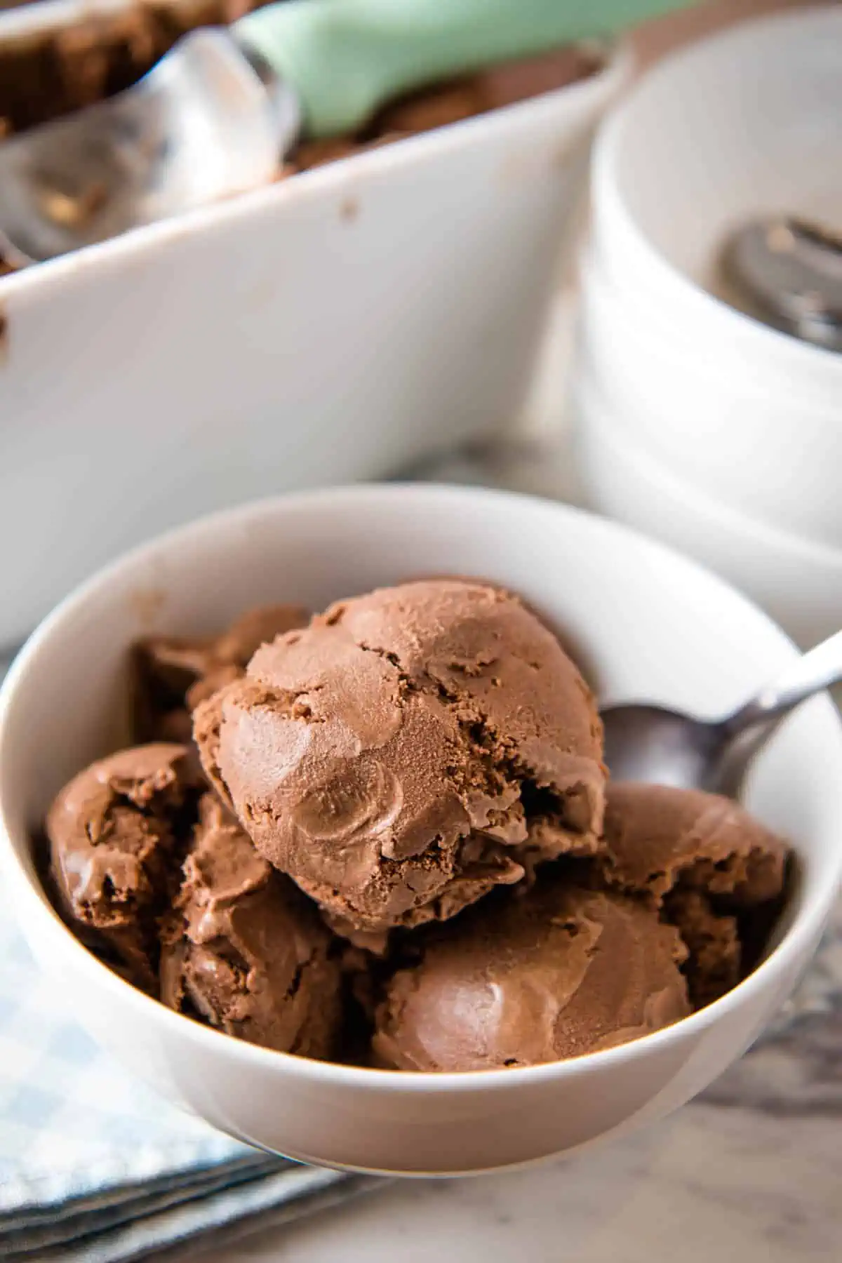 white bowl with scoops of old-fashioned homemade chocolate ice cream and spoon