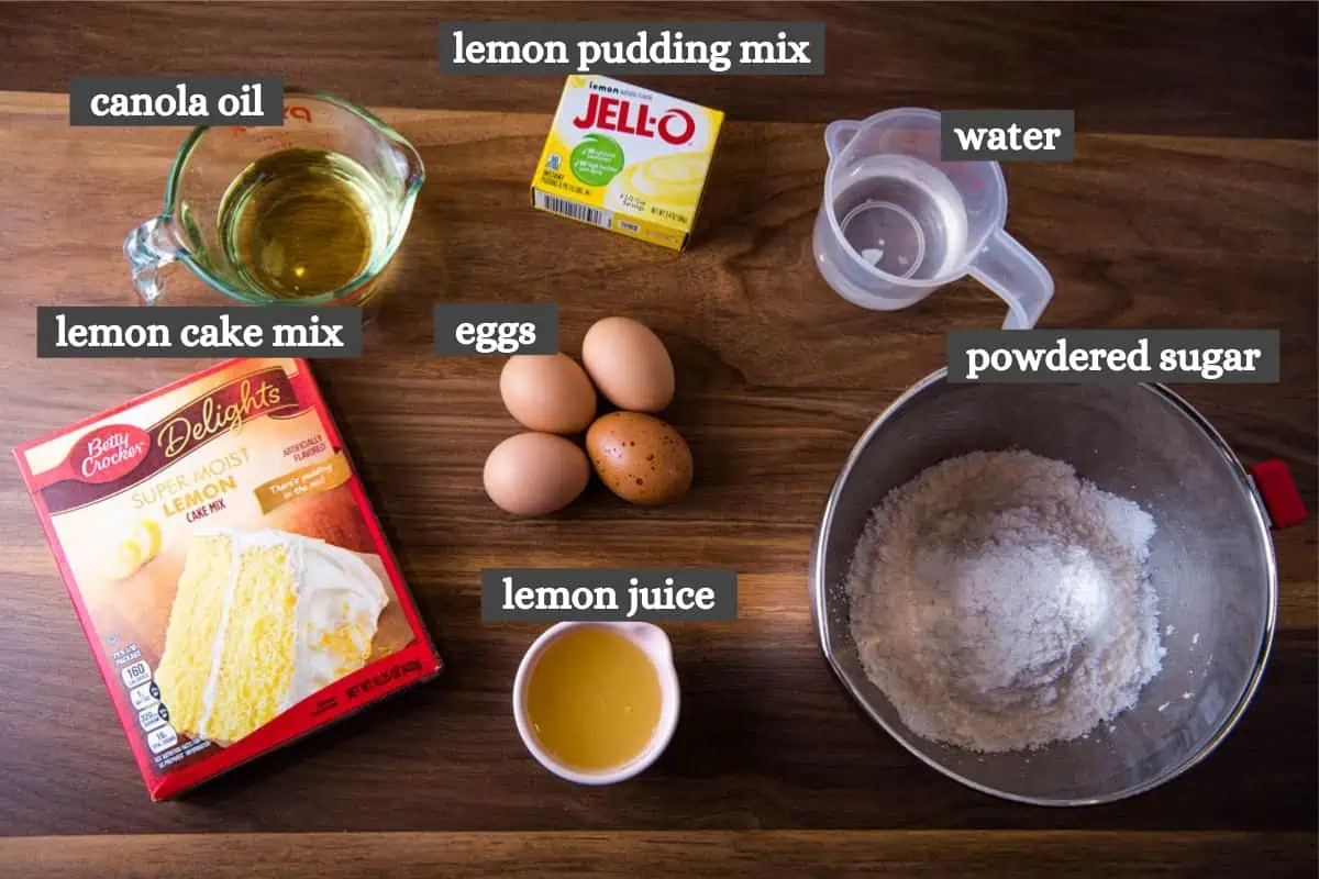 lemon poke cake with lemon glaze ingredients on wood countertop