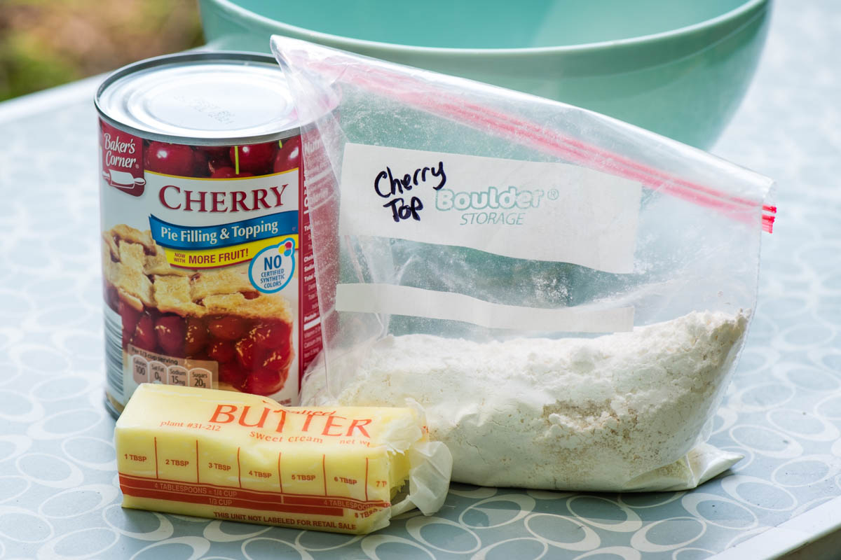 Dutch oven cherry cobbler ingredients lined out on a small gray table