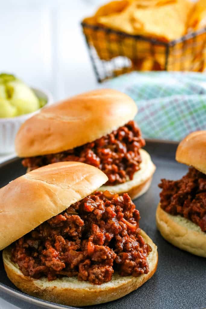 crockpot sloppy joes on hamburger buns on a large gray plate