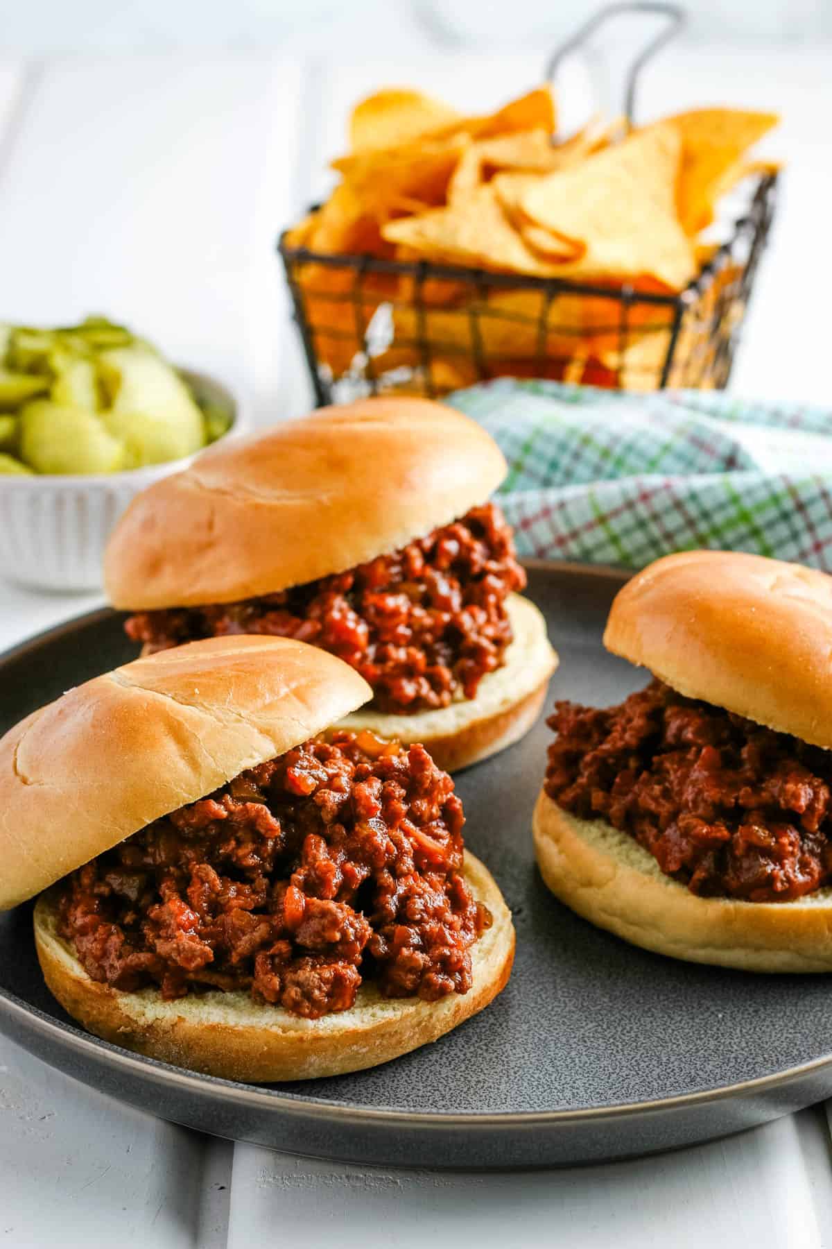 crockpot sloppy joes on hamburger buns on a large gray plate