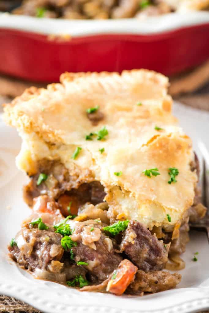 sliced wedge of beef pot pie on a small white saucer